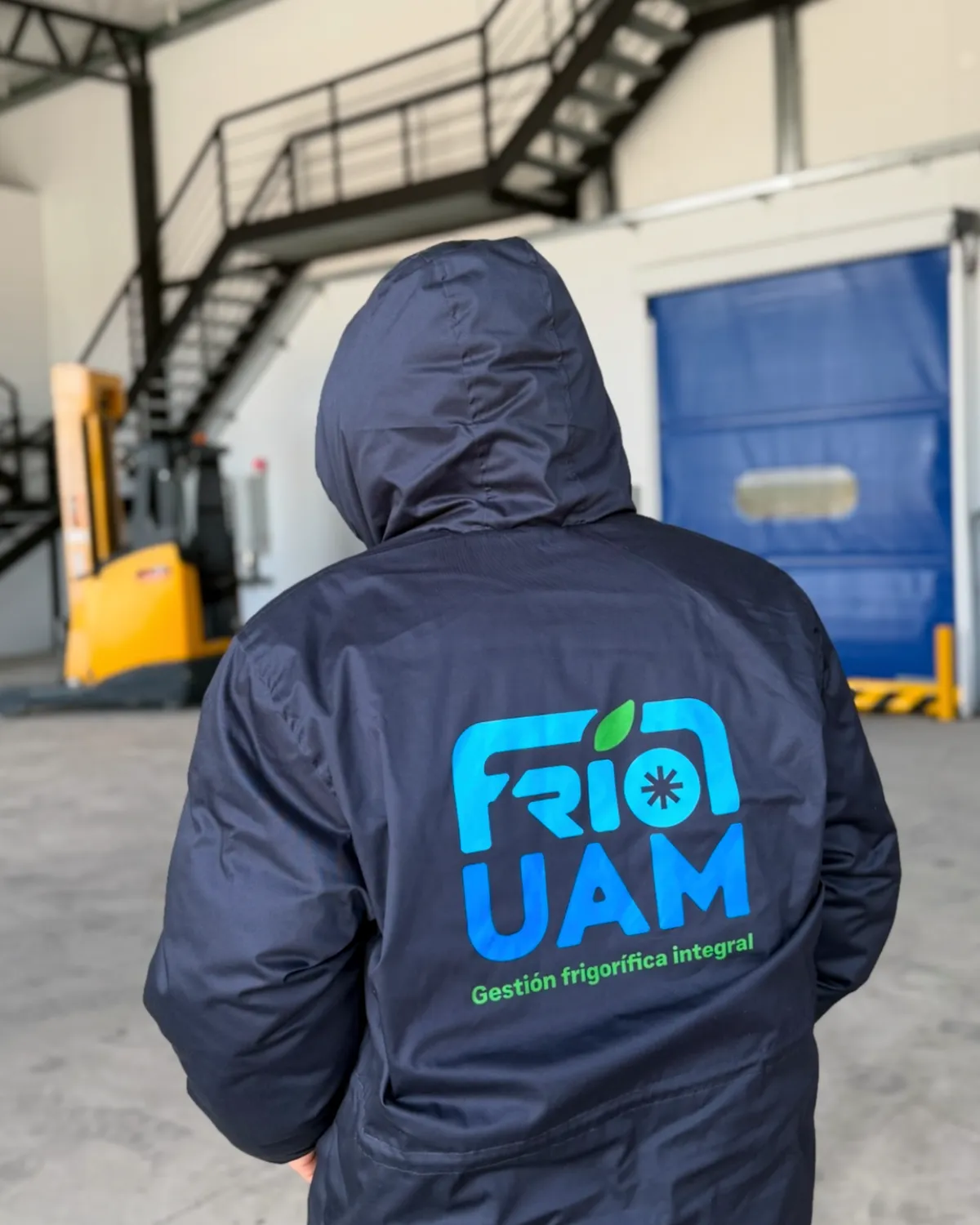 Operario de Frío UAM de espaldas, con uniforme de la empresa, en la playa de maniobras